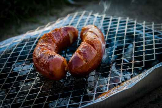 two sausages on charcoal grill